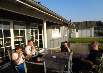 Sommerferie med Purkærhus hvor unge mennesker sidder og hygger sig om en havesæt i aftensolen